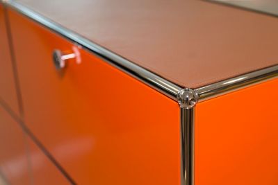 Detailaufnahme: USM Sideboard in Orange mit cognacfarbener Lederauflage "Leather on Top".